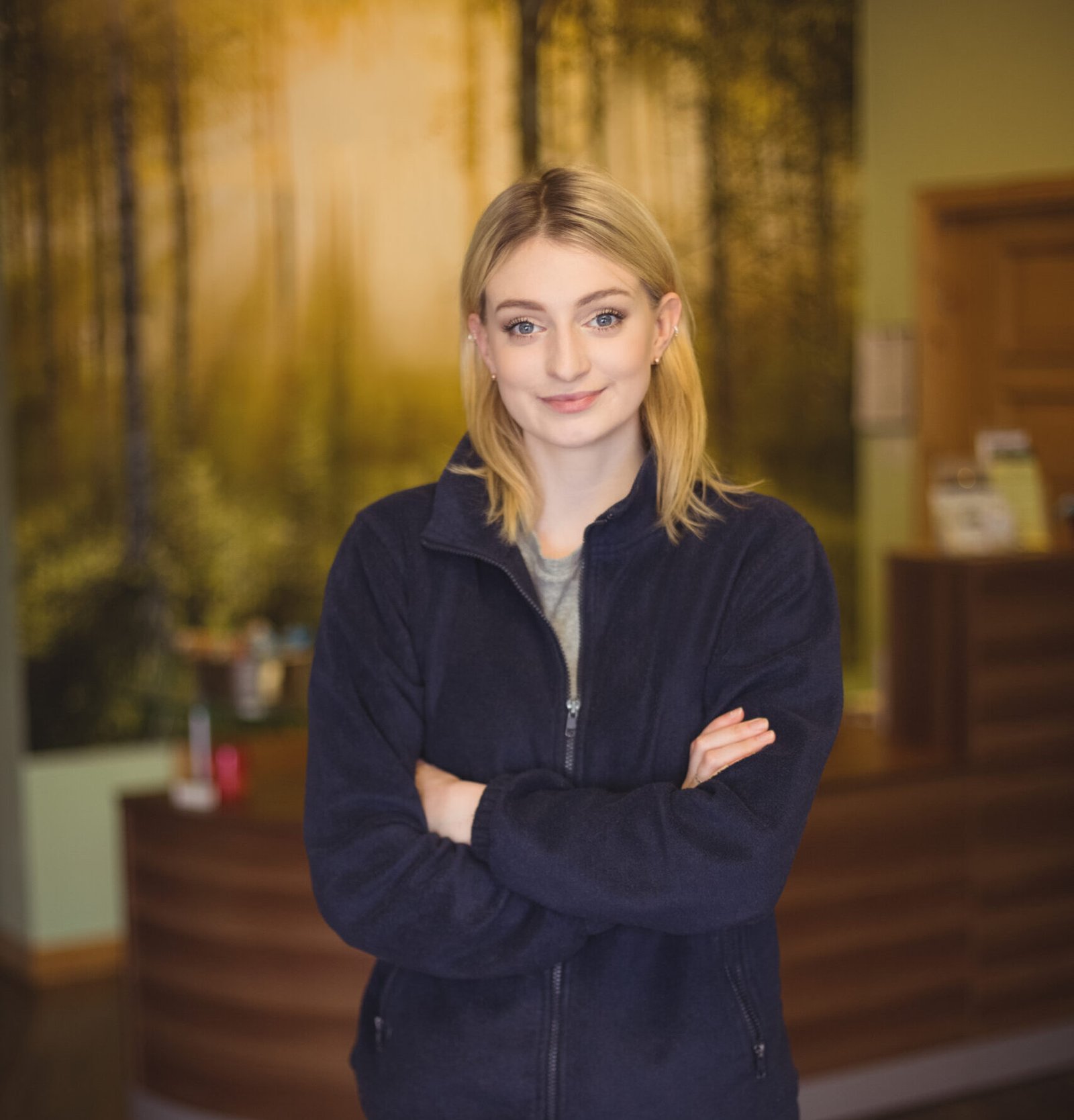 Portrait of confident woman standing with arms crossed in office